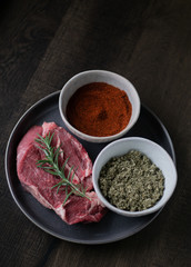 Raw Steak with Spices on Wooden Table