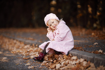 Fashionable little girl in a pink coat