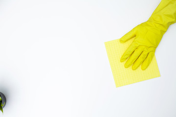 Close up of worker hand wiping dust in office in yellow gloves