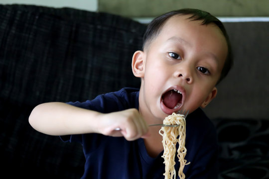 Little child boy eating Instant noodles.