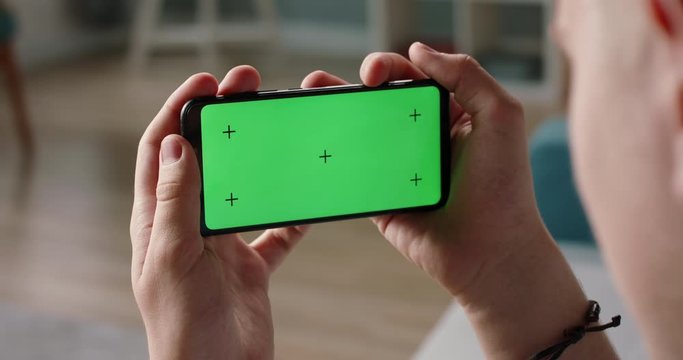 Man using a smart phone with mock up green screen, talking while having an online conference - online education, communications concept close up 4k video template