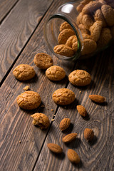 Italian amaretti biscuits poured out from a jar. Crunchy almond cookies with whole almond nuts.