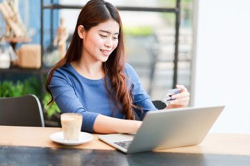 Asian woman using computer laptop and drink coffee work from home concept