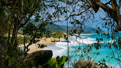 Coast view of the National Park Tayrona in Colombia. Caribbean Sea paradise, natural scenery with a bright blue sky and beautiful beach.