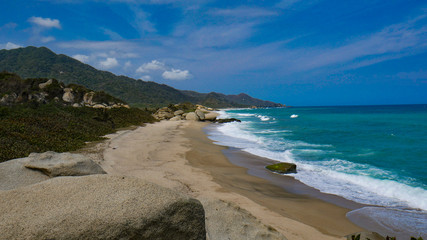 Coast view of the National Park Tayrona in Colombia. Caribbean Sea paradise, natural scenery with a bright blue sky and beautiful beach.