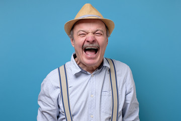 Senior angry and mad man screaming frustrated and furious, shouting with anger