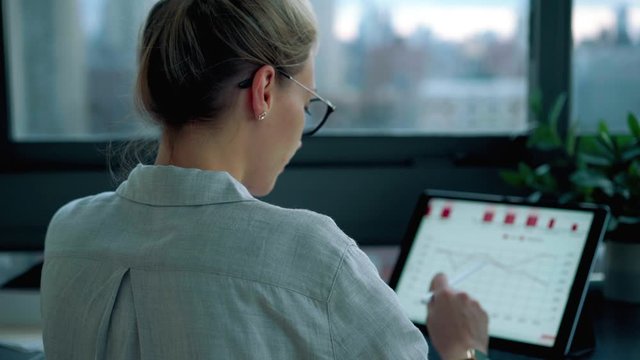 Skilled woman searching data information on modern digital tablet connected to 4g for browsing statistic platform, Caucasian female entrepreneur working with graph charts using electronic stylus 