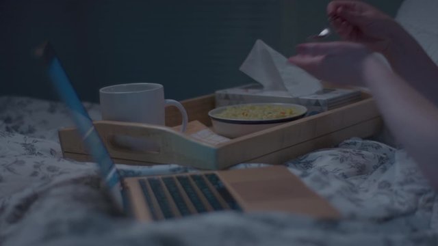 Woman Takes A Bite Of Soup, Sips Tea, Blows Her Nose, Watches TV Show On Laptop