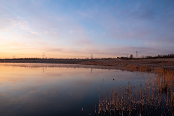 Naklejka premium Gorgeous sunrise over the lake with reflection of the sun on the lake and spring