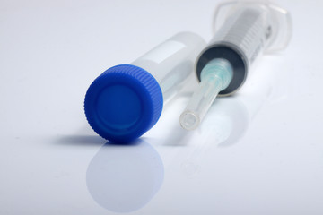 Close up shot of medical syringe and test tube for laboratory testing purpose, isolated on white background