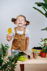 Cheerful six year old girl laughing while taking a break from replanting