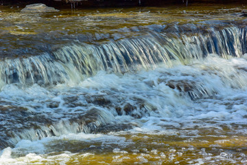 Fototapeta na wymiar Baird Creek waterfall in slow motion, on the Niagara Escarpment, close-up view.