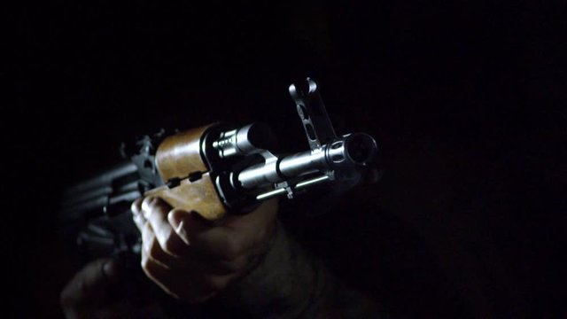 Slow motion closeup of man reloading AK47