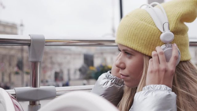 Teenage Girl Putting On Headphones On Bus