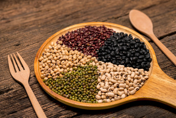 Various type of cereal grains ,5 colors beans,black beans, red beans,white beans,green beans,soybean. Five different kinds of beans and pea on wood background
