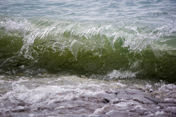 sea landscape is a pebbly beach with waves in white foam