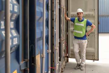 industrail background of caucasian containers yard and cargo inspector working at containers loading area