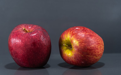 Fruits of macã (Malus domestica) in natura on dark and mirrored background