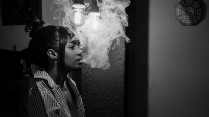 Beautiful black woman smoking vape