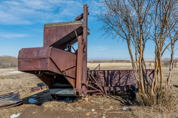 Vintage pull-type combine abandoned in a field in Saskatchewan, Canada