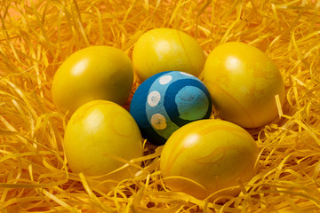 Fototapeta na wymiar yellow easter eggs on straw background
