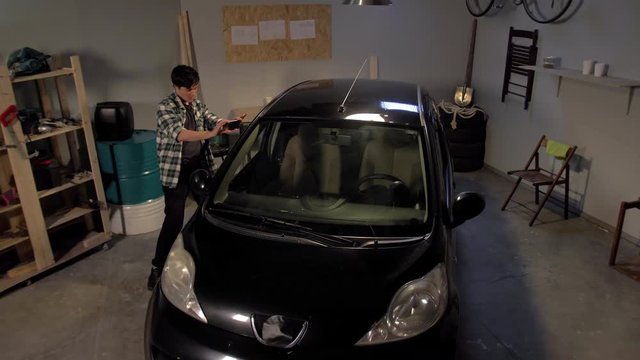 Guy taking pictures of a car in a garage