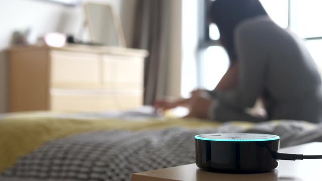 Millennial Woman Using Alexa Smart Home Assistant, Painting Nails in the Background