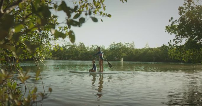 Mother and daughter paddle boarding
