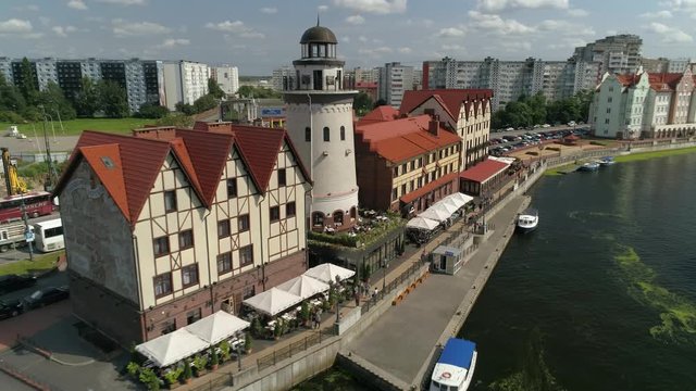 Drone approach Kaliningrad city center famous fishing village tourist new quarter. Russia beautiful cityscape from a height. Pedestrian embankment lighthouse on river, restaurants. Summer day
