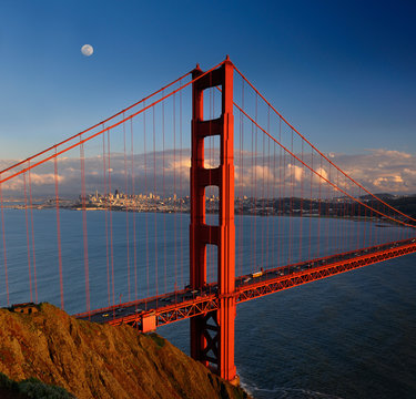 Golden Gate Bridge with San Francisco skyline and moon at sunset