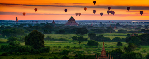 Scenic sunrise with many hot air balloons above Bagan in Myanmar. Bagan is an ancient city with...