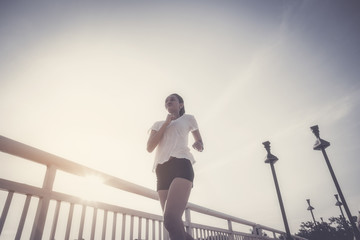 Healthy woman doing exercises and warm up before running and jogging on bridge at morning