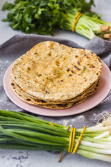 Plain flatbread stuffed with green herbs. Indian traditional chapati, naan, roti or Mexican tortilla of wheat flour. Vegan and vegetarian healthy food.