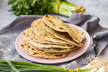 Plain flatbread stuffed with green herbs. Indian traditional chapati, naan, roti or Mexican tortilla of wheat flour. Vegan and vegetarian healthy food.