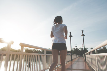 Healthy woman doing exercises and warm up before running and jogging on bridge at morning