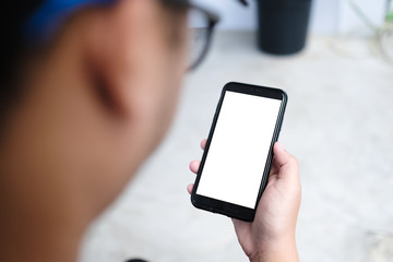 Closeup of male hand holding and using modern smart phone with blank screen for your text or content, with city bokeh