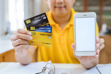 the young man wears a yellow shirt holding blank white credit card mockup. Plain creditcard mock up template with electronic chip holding arm. Plastic bank-card display front design. Business branding