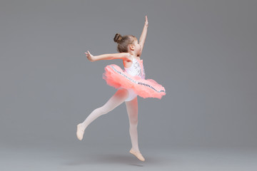 Cute adorable ballerina little girl in pink tutu dance practices ballet dancing