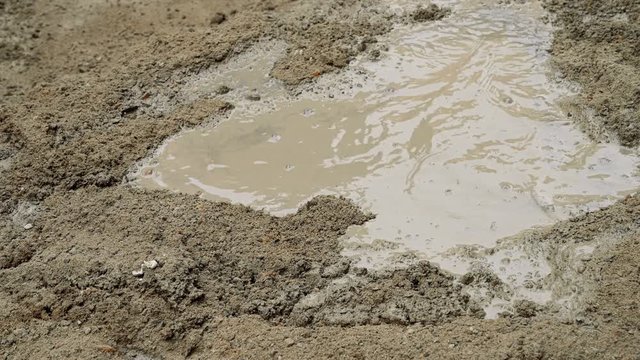 Indian labour mixing cement and water manually on floor using a shovel. Stcok footage.