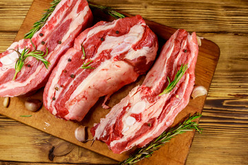 Raw pork ribs with spices, garlic and rosemary on wooden table. Top view