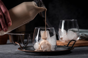 Irish cream coffee liqueur with ice on dark background