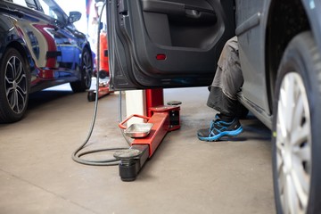 mechanics foot hanging out of car in garage