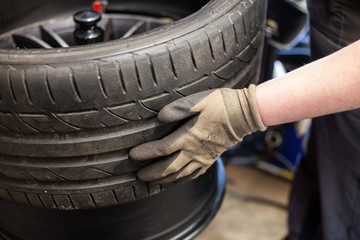 man mounting tire onto rim with machine in garage