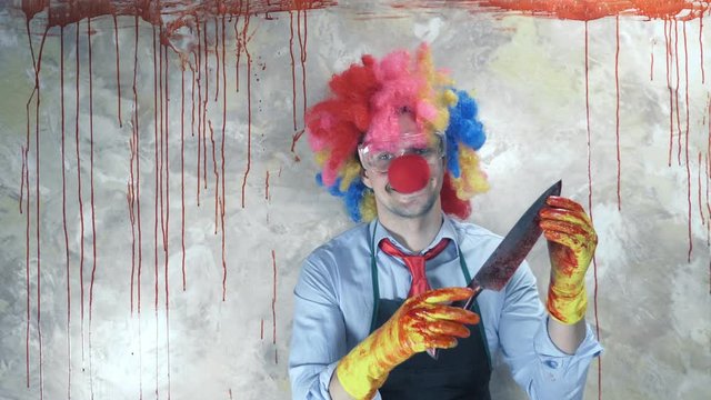 the man in the clown suit in the background of the bloody wall with a knife