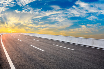 Fototapeta premium Asphalt highway road and sky sunset clouds landscape.
