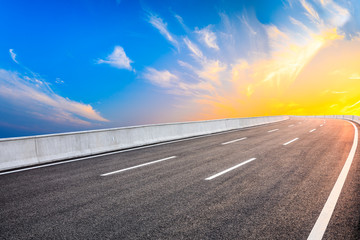 Naklejka premium Asphalt highway road and sky sunset clouds landscape.