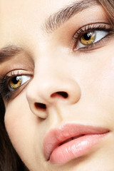 Naklejka premium Closeup macro portrait of female face with pink lips and smoky eyes beauty makeup.