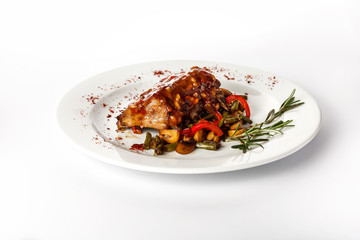 A piece of fried meat in mushroom sauce isolated on a white background. With fried mushrooms and vegetables.