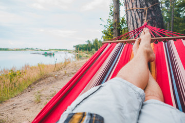 men legs. laying on hammock view lake view