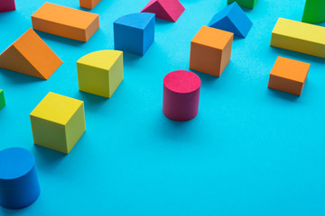 Fototapeta premium Set of colorful geometric cube or block toy on blue background with copy space. Abstract pattern design composition by shape and form. Education, business solution and creative design product concept.